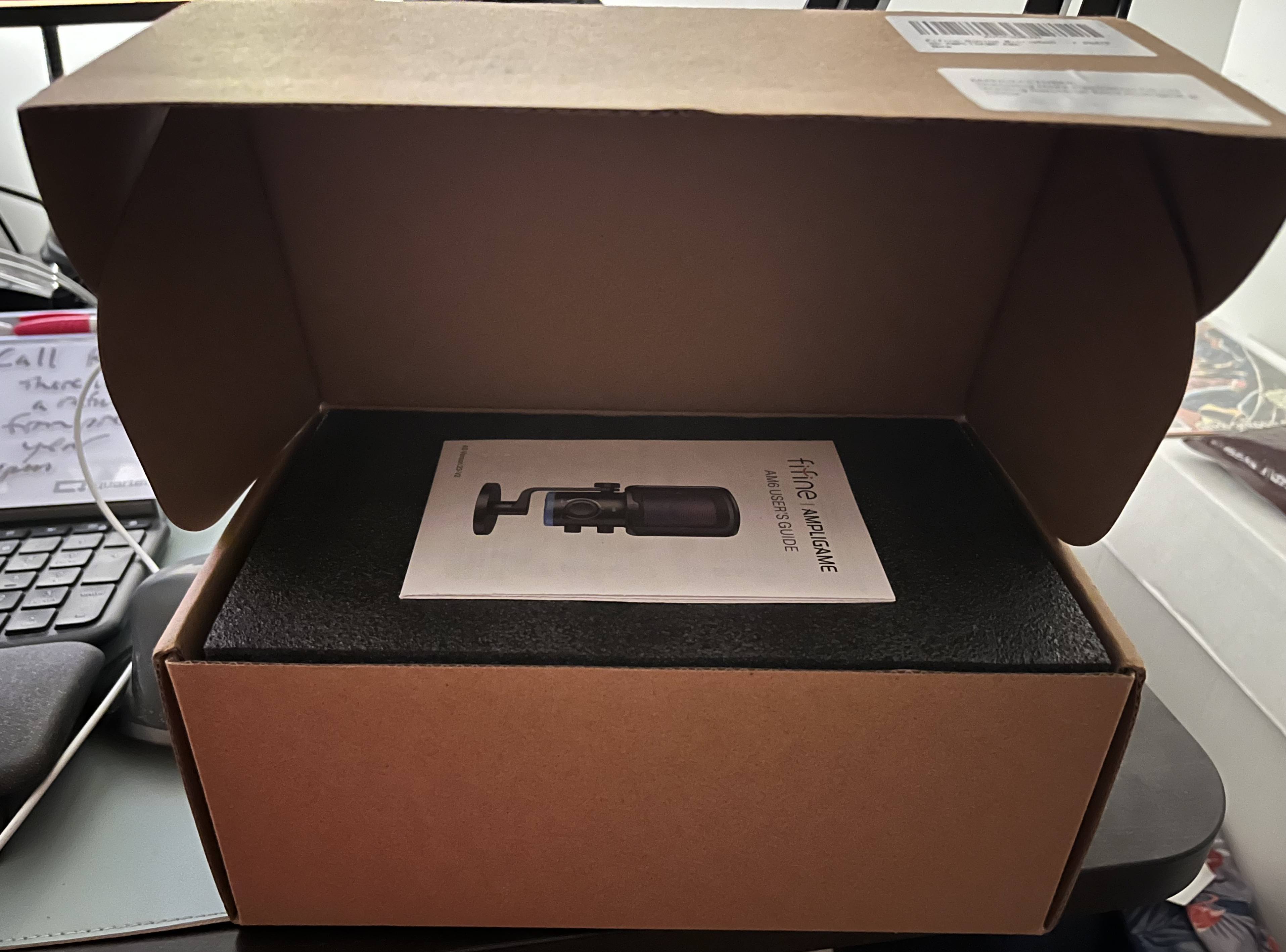 Fifine Ampligame AM6 Condenser Mic box open with instruction manual on top
